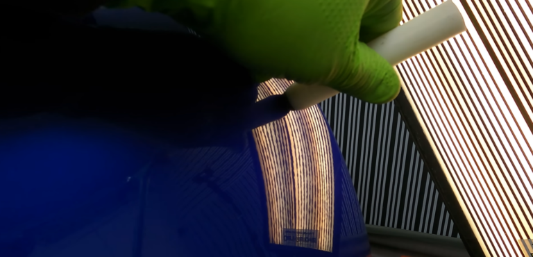 PDR technician using specialized rod tool for dent removal